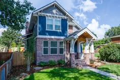 a house with blue shutters and green grass in the front yard on a sunny day