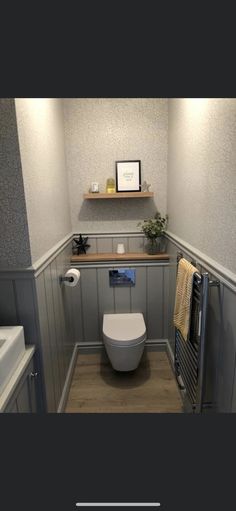 a bathroom with a toilet, sink and towel rack in the corner on the wall