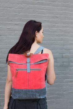 a woman wearing a red backpack with the words range backpack on it's back