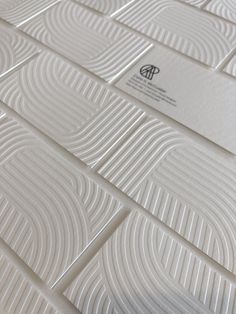 a close up view of some white tiles on the floor with an embossed pattern