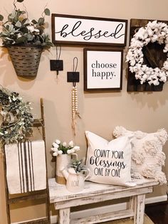 a table with some pillows on top of it next to flowers and other items that are hanging on the wall