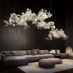 a living room filled with furniture and flowers hanging from it's ceiling light fixture