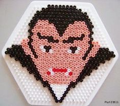 an image of a man made out of beaded beads on a white plate with black and red accents