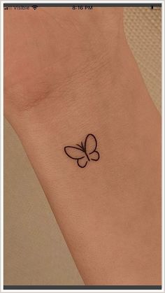 a small butterfly tattoo on the ankle is shown in black ink, and it looks like an