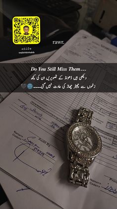 a watch sitting on top of some papers with writing in arabic and an image of a man's face