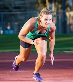 a woman is running on a track with her hands behind her back as she prepares to hit the tennis ball