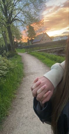 a close up of a person's hand on a dirt road