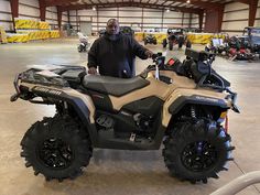 a man standing next to an atv in a warehouse