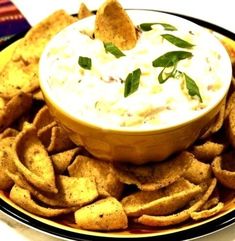 a plate with chips and dip on it