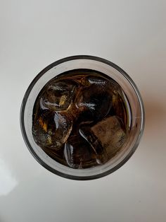 a glass filled with ice sitting on top of a table