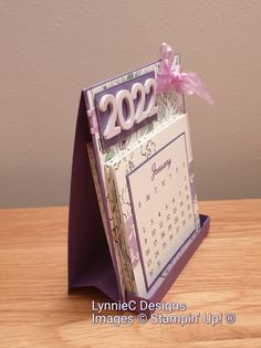 a desk calendar sitting on top of a wooden table