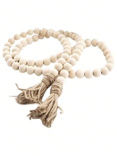 a wooden beaded necklace with tassels on a white background