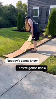 a man is standing in front of a house with a cardboard ramp on the sidewalk