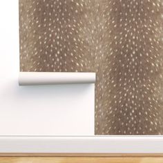 an animal print wallpaper with white spots on brown paper next to a wooden floor