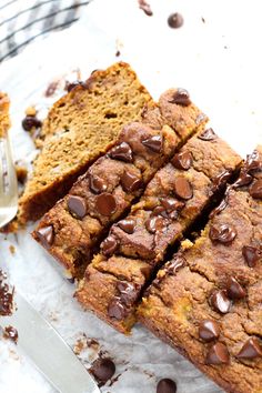 chocolate chip zucchini bread sliced on top of parchment paper next to a knife