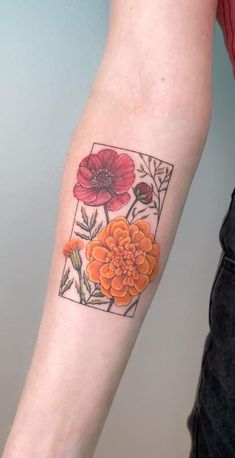 a woman's arm with an orange flower and leaves tattoo on the left forearm