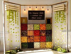 a display in a building with lots of fruits and vegetables on the wall behind it