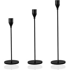 three black candles are standing next to each other on the same stand, and one is empty