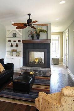 a living room filled with furniture and a fire place in the middle of a room