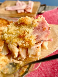 a close up of a spoon with food on it and another dish in the background