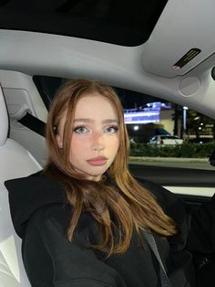 a woman sitting in the back seat of a car with her hand on her hip