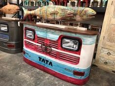 a fish on top of a food truck in a garage next to another vehicle with the hood open