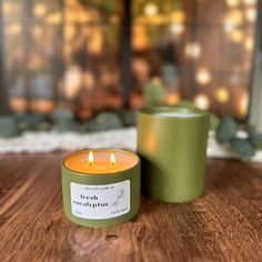 two candles sitting on top of a wooden table