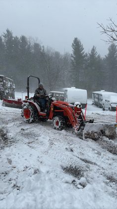 a man driving a tractor in the snow