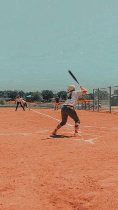 a baseball player holding a bat on top of a field in front of other players