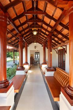 the inside of a building with wooden pillars and benches lined up against each other on either side