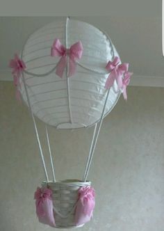 a hot air balloon with pink bows hanging from the ceiling