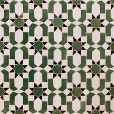 a green and white tiled wall with geometric designs