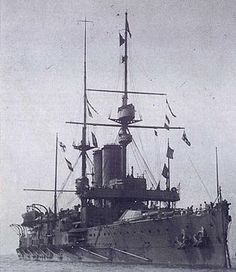 an old black and white photo of a ship in the water with flags on it