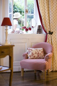 a red and white chair sitting in front of a window