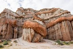 large rock formations in the desert under a cloudy sky