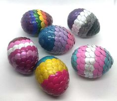 several colorful balls are arranged on a white surface with one ball painted like a fish