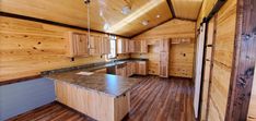 an empty kitchen with wooden walls and flooring