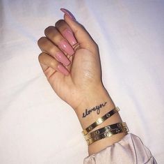 a woman's hand with two bracelets on it and the word always written in cursive writing