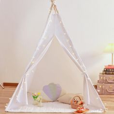 a white teepee with lights on it in a child's room