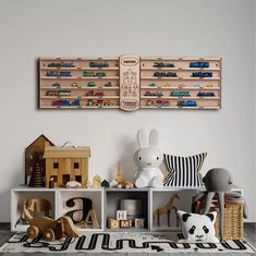 two wooden shelves filled with toys on top of a white rug in front of a wall