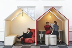 two people sitting on chairs in the shape of houses, one with a man and woman inside