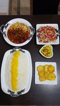 the table is full of different types of food on it, including rice and other foods