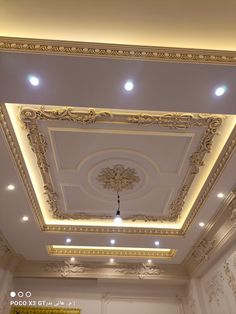 the ceiling in this room is decorated with gold trimmings and decorative lighting fixtures