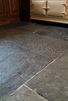 a kitchen floor with an oven in the background