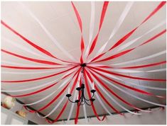 a chandelier with red and white streamers hanging from it's ceiling