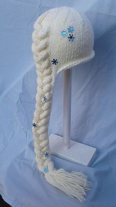 a white knitted hat with braids and blue stars on the brimmed