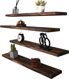 three wooden shelves with various items on them and one shelf holding an alarm clock, potted plant and other objects