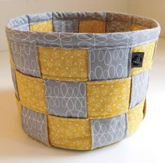 a yellow and gray basket sitting on top of a table