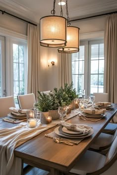 a dining room table is set with place settings and candles for the centerpieces