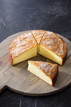 a cake that has been cut into pieces on a wooden board with one slice missing